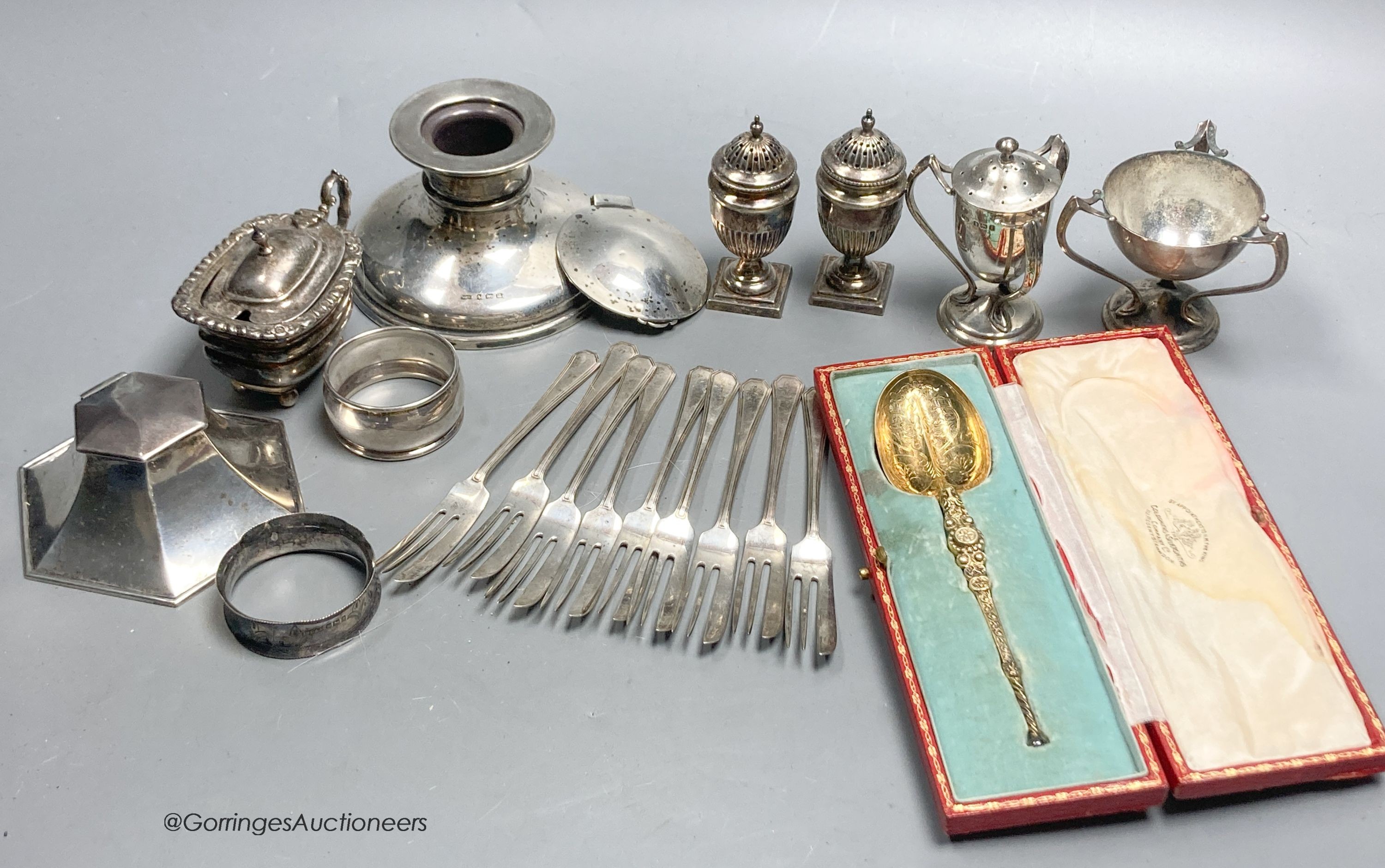 Sundry small silver including cased spoon, two mounted inkwells, two small trophy cups, condiments, cake forks etc.